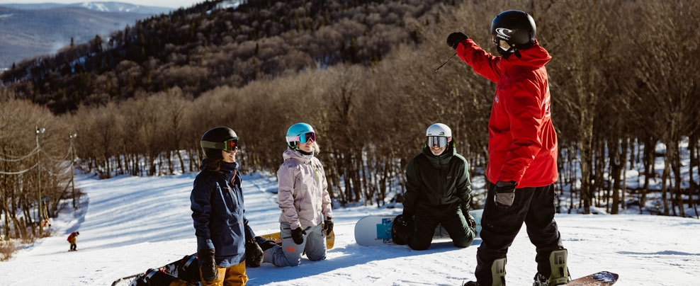 Groupe de personnes en train de regarder leur moniteur de ski.