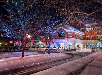 Bâtiment de l'Auberge Godefroy vu de nuit en hiver et décoré de lumières de Noël.