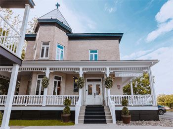 Extérieur d'une maison bien entretenue sous un ciel ensoleillé.