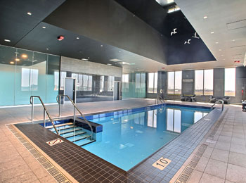 Piscine intérieure de l'hôtel dans une salle vitrée.