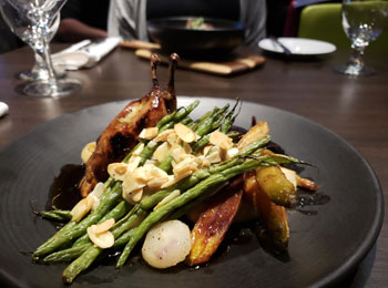 Assiette de volaille avec asperges, carottes et amandes.
