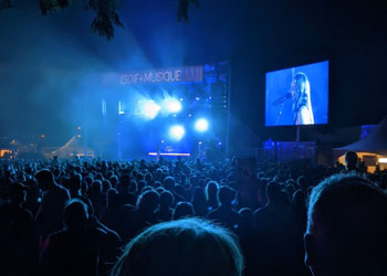 Foule en soirée sous une lumière bleutée.