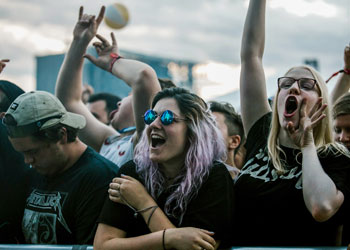 Jeune femme souriante dans la foule d'un festival.