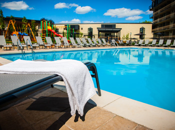 La piscine extérieure entourée de chaises longues à l'Hôtel Castel.