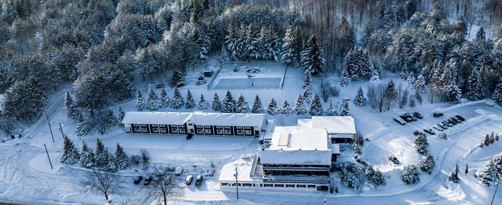 Vue aérienne de l’hôtel et de la forêt environnante sous un couvert de neige.