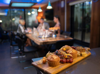 Planche déjeuner et groupe de personnes attablées dans un restaurant.