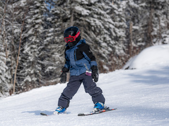 Enfant qui apprend à skier sur la pente.