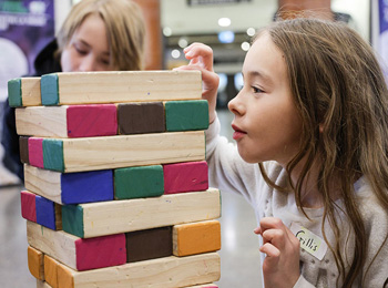 Deux enfants qui jouent à un jeu de jenga au musée.