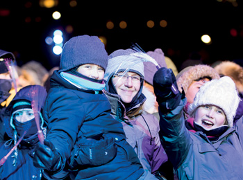 Mère et ses enfants bien emmitoufflés pour profiter des célébrations.