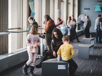 Parents et enfants à l'exposition de l'observatoire de la capitale.