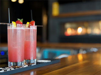 Deux cocktails fruités sur un comptoir de resto-bar