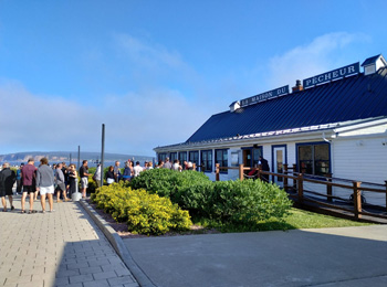 File d’attente à l’extérieur d’un restaurant appelé La Maison du Pêcheur.