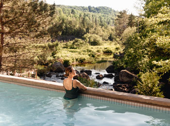 Femme en train de contempler la nature dans une piscine.