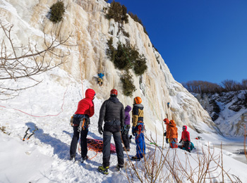 Groupe de personnes au pied d’une paroi glacée