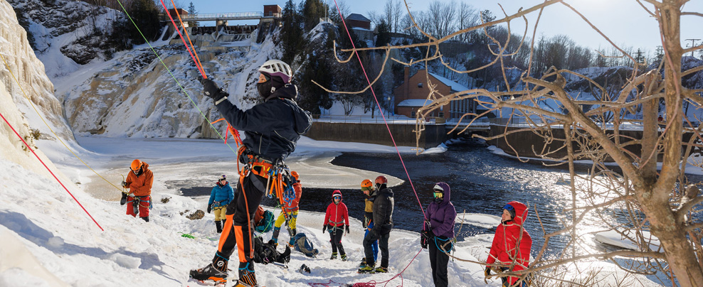 Groupe de personnes qui attendent pour escalader la paroi de glace.