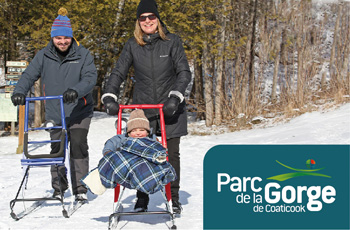 Deux parents et leur enfant explorant les sentiers en trottinette des neiges