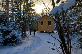 Deux randonneurs à l’extérieur d’un refuge en pleine nature