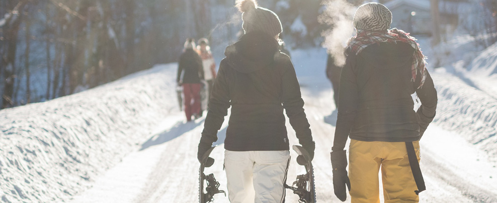 Couple en habits de neige sur un sentier de raquette.