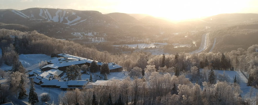 Vue aérienne de l’Hôtel Mont-Gabriel et d’un domaine skiable en arrière-plan.