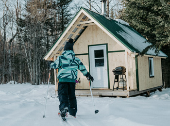 Enfant en skis qui retourne au chalet.