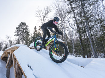 Femme en train de faire du fatbike dans la neige.