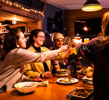 Groupe d’amis autour d’une table en train de porter un toast