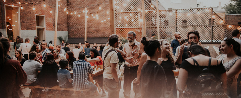 Foule rassemblée sur une terrasse festive.