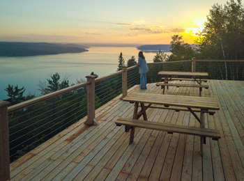 Femme sur une terrasse au bord de la rivière Saguenay au Cap à Leste.